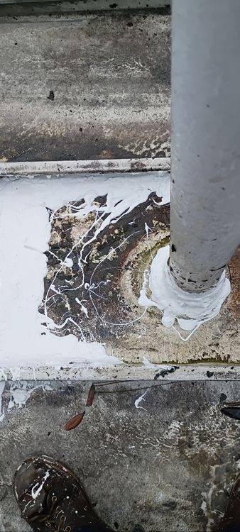 Weathered coating and reinforcement at an existing pipe penetration.
