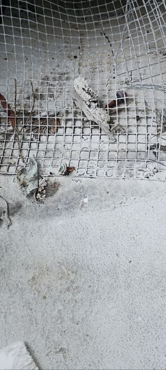 Worn surface material with reinforcement exposed.