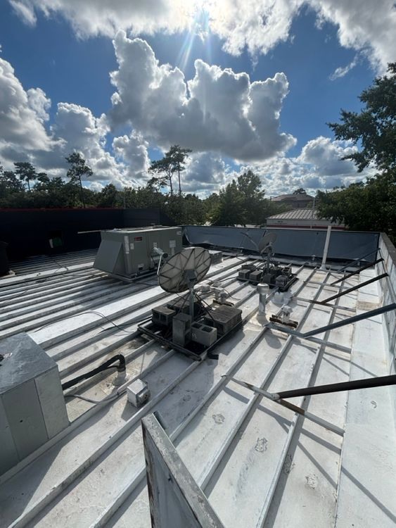 The convenience-store roof and its rooftop installations surrounding the localized repair area.
