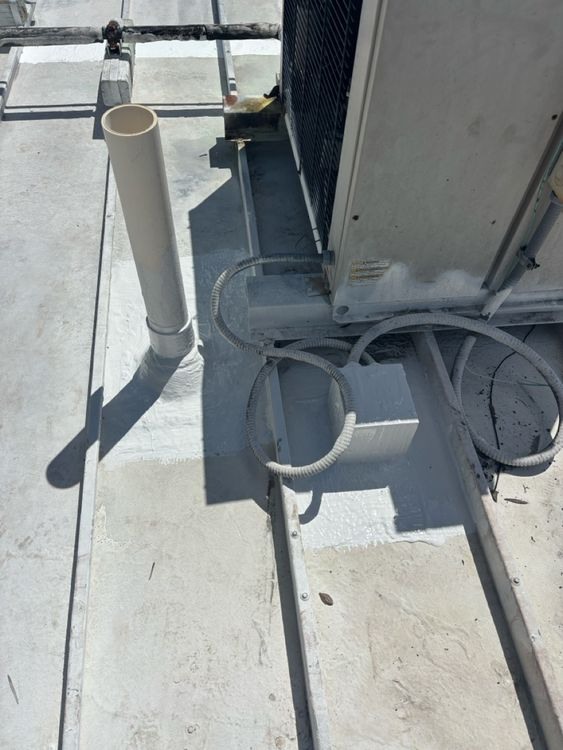 Treatment at the junction of a pipe penetration and equipment curb.